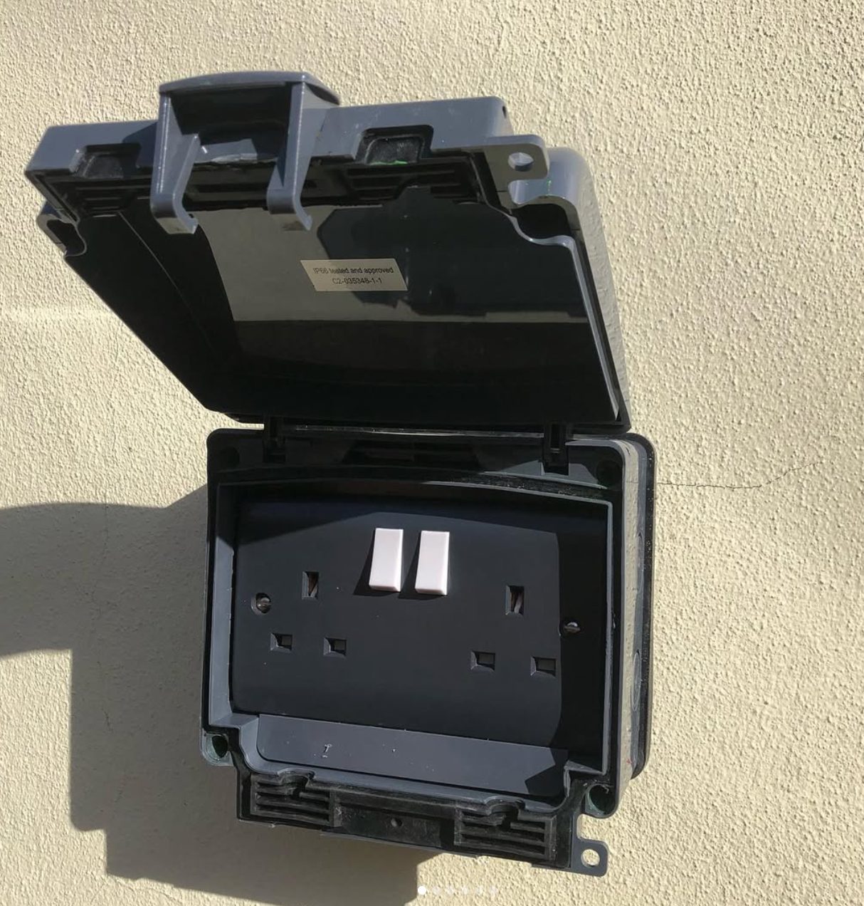 Weatherproof outdoor socket fitted to a wall